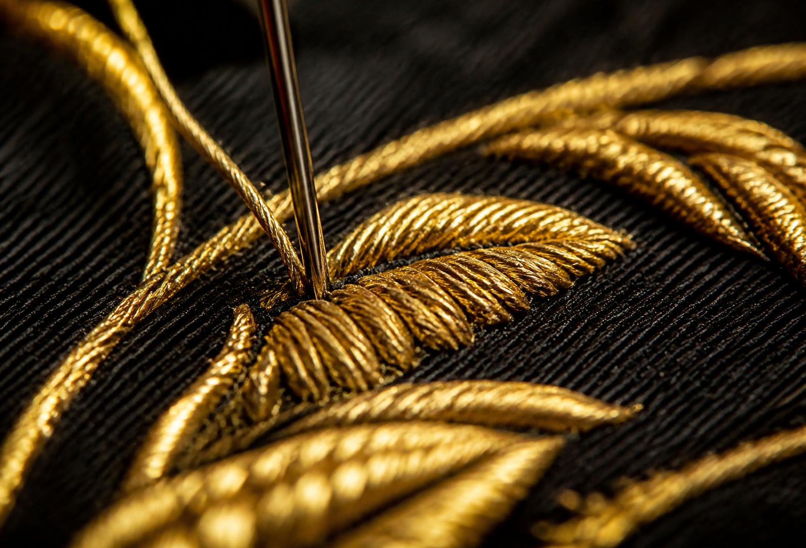 Macro d'une broderie de fil d'or sur un tissu noir